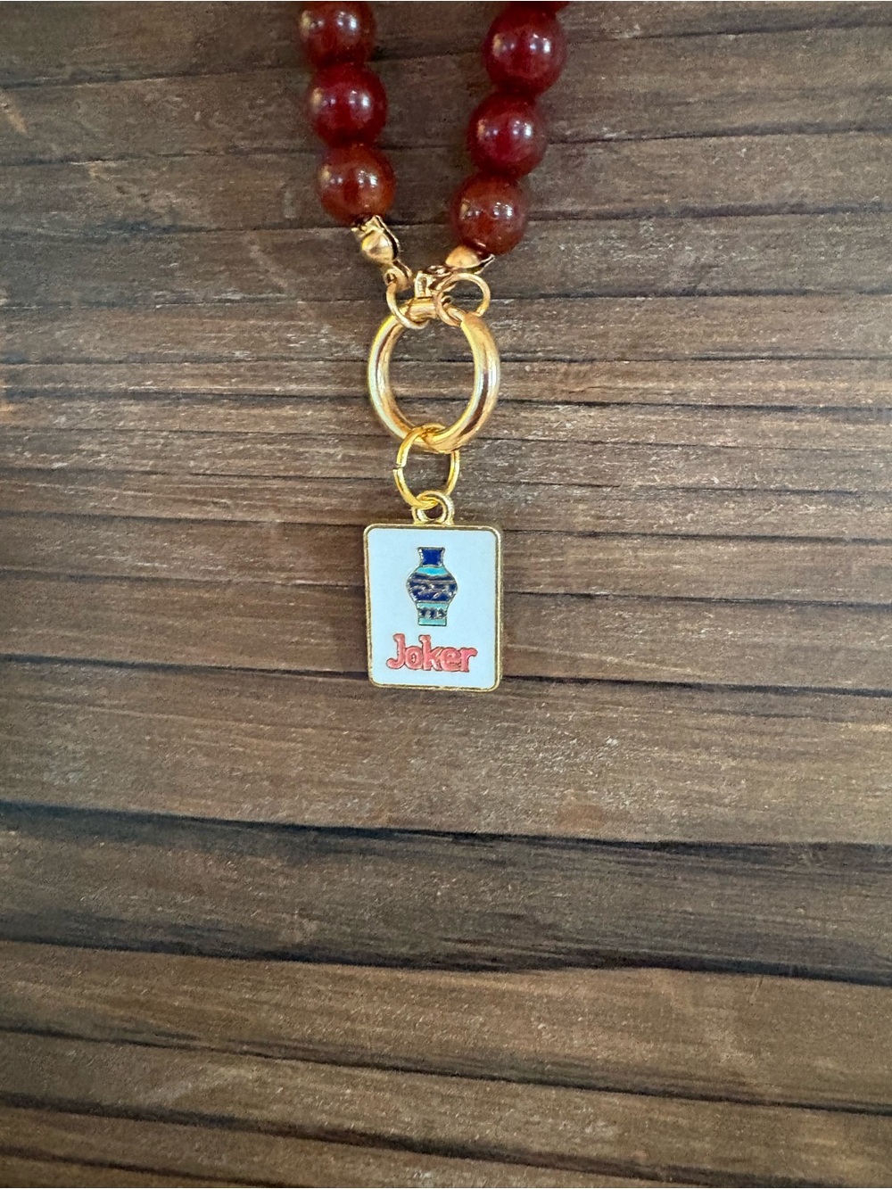 Gold-Tone Red Bead Necklace with Joker Pendant